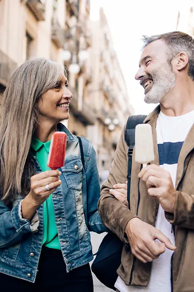 Kortlopende reisverzekering Een paar ijs van middelbare leeftijd gaat eten door een voetgangersgebied.